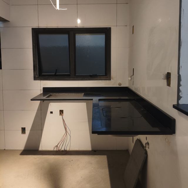 Cozinha com bancada em L de granito preto